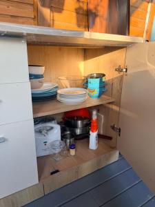 a cupboard with plates and dishes in it at Cabana Maya in Corbu