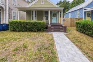 a home with a porch and a blue house at Odie's Oasis on Union in Brunswick