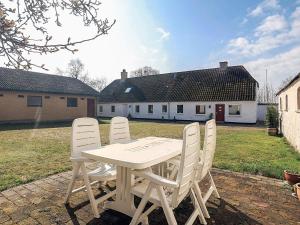 a white table and chairs in a yard at 4 star holiday home in Aabybro in Åbybro