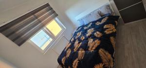 a bedroom with a bed with a comforter and a window at Ferienwohnung in Achim Zentrum Apartment in Achim