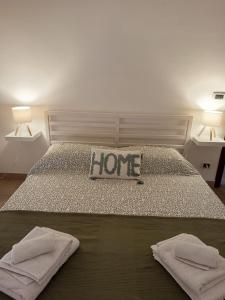 a bedroom with a bed with a home sign on it at Riflessi nosTrani - Seaside Rooms in Trani