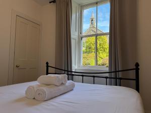 a bed with towels sitting on it in front of a window at Glenrigh House - The Garden Flat in Fort William