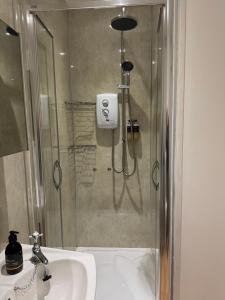 a bathroom with a shower and a sink at Glenrigh House - The Garden Flat in Fort William +11 photos