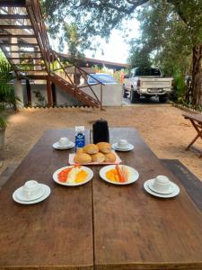 a wooden table with plates of food on it at Sunsand Beach Suítes e Hostel in Camocim