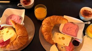 two plates of food with bread and cheese and orange juice at Golden Boutique in Basel