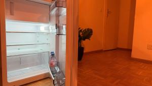 an empty refrigerator with its door open in a room at Golden Boutique in Basel
