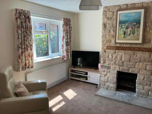 a living room with a fireplace and a television at 3 bed house in Winterbourne Abbas in Winterborne Abbas