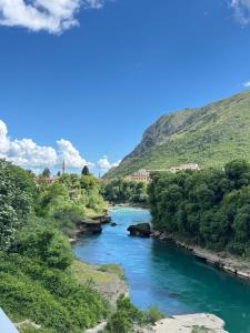a river in a valley with green hills at Guest House Nova in Mostar