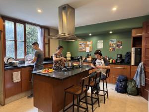 a group of people in a kitchen preparing food at Sereno Hostels in Bogotá