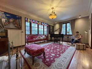 a man sitting in a living room with a piano at Sereno Hostels in Bogotá