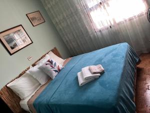 a bedroom with a blue bed with towels on it at Quarto triplo - Casa Azul - Águas de São Pedro in Águas de São Pedro +31 photos