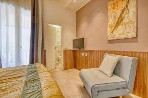 a bedroom with a bed and a chair and a tv at Hotel Everest - Bar e Ristorante in Gabicce Mare