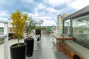 a balcony with benches and trees on a building at Studio Bangalô Belém Hospedagem in Belém