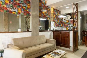 a couch in a room with a wall covered in tiles at Studio Bangalô Belém Hospedagem in Belém