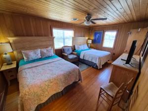 a bedroom with two beds and a chair in a room at Sand Spur Cottages in Nags Head