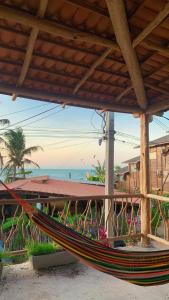 a hammock on a beach with the ocean in the background at Sunsand Beach Suítes e Hostel in Camocim
