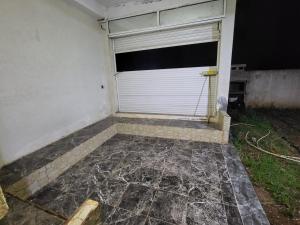 a garage with a white door and a window at عين السلطان ain sultan in Imouzzer du Kandar