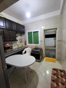 a kitchen with a white table and a stove at عين السلطان ain sultan in Imouzzer du Kandar