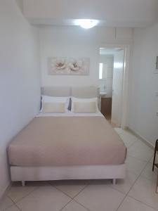 a white bedroom with a large bed in a room at Georgias House in Lefkada