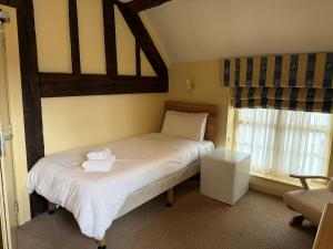 a bedroom with a bed with white sheets and a window at Yesterday's Guest House in Newtown