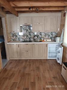 a kitchen with wooden cabinets and a wooden floor at Chatka Puchatka in Gołubie
