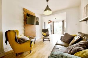 a living room with a couch and two chairs at King size room in home for couple or females in Hornchurch