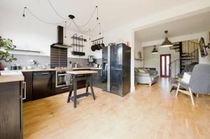 a kitchen and living room with a table and appliances at King size room in home for couple or females in Hornchurch