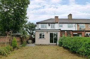 a large white house with a fence and a yard at King size room in home for couple or females in Hornchurch