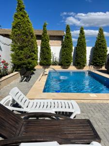 a swimming pool with two lounge chairs and trees at My_willa_Buzovna in Zağulba Bağları