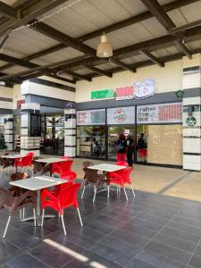 a restaurant with tables and red chairs in a building at The Dunamis in Accra