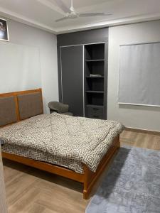 a bedroom with a bed and a chair and a window at The Dunamis in Accra +40 photos