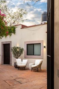 eine Terrasse mit zwei Stühlen und einem Fernseher an der Wand in der Unterkunft Gran Faena in Aguascalientes