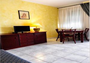 ein Wohnzimmer mit Tisch und Stühlen und ein Esszimmer in der Unterkunft Hotel Blue Rose's in Mesagne