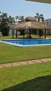 a straw hut sitting next to a swimming pool at Escape Acapulco in Acapulco