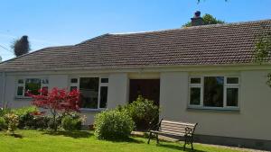 a white house with a bench in front of it at Hawk Hill in Rosemarkie