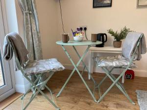 a table and two chairs in a room with a table at Hawk Hill in Rosemarkie