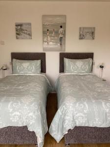 two beds sitting next to each other in a bedroom at Hawk Hill in Rosemarkie