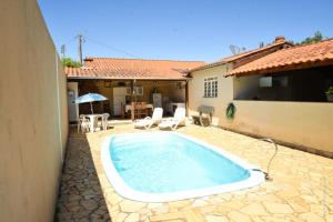 a swimming pool in a yard next to a house at Casa Completa em Socorro SP - Com Piscina, Churrasqueira e Roupa de Cama in Socorro