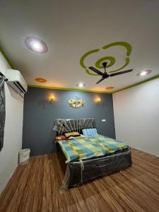 a bedroom with a bed with a ceiling fan at Mandys Farm House in Manjhāoli