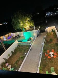 an aerial view of a swimming pool at night at Mandys Farm House in Manjhāoli