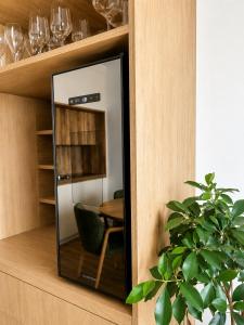 a mirror in a cabinet with a table and a chair at Sleep & coffee by KAFEC in Komárov