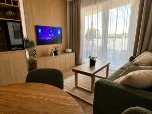 a living room with a couch and a tv and a table at Sleep & coffee by KAFEC in Komárov