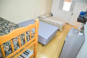 a small room with two beds and a crib at Casa Completa em Socorro SP - Com Piscina, Churrasqueira e Roupa de Cama in Socorro +50 photos