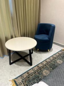 a table and a blue chair and a table and a chair at Hotel route 54 in Bathinda