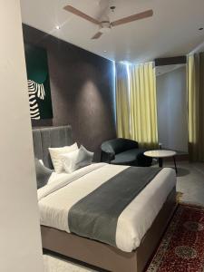 a bedroom with a large bed and a chair at Hotel route 54 in Bathinda