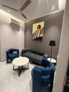 a living room with blue chairs and a couch and tables at Hotel route 54 in Bathinda