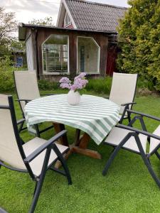 a picnic table with two chairs and a vase of flowers at Gästhus Vejbystrand in Vejbystrand