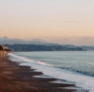 a beach with the ocean and mountains in the background at APART HOTEL KOBULETi in Kobuleti +9 photos
