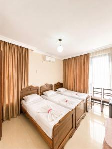 a bedroom with three beds and a window at APART HOTEL KOBULETi in Kobuleti