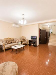 a living room with a couch and a tv at APART HOTEL KOBULETi in Kobuleti